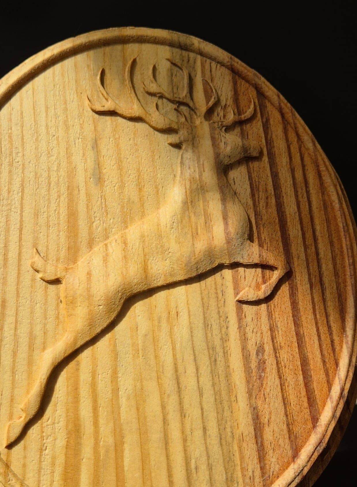 Cerf bondissant sculpté en relief sur un médaillon en bois massif