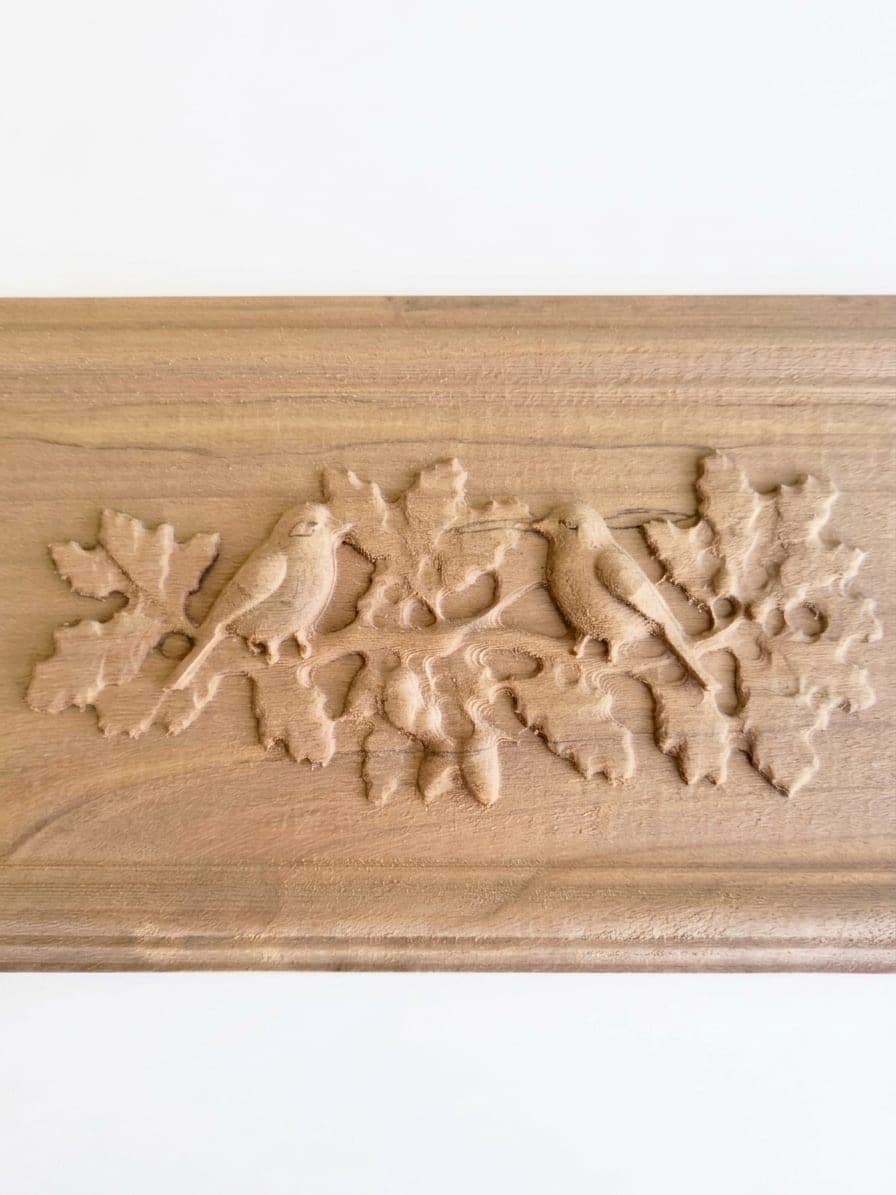 Détail de la Cimaise et ses oiseaux : deux passereaux face à face sur une branche de chêne, sculptés en relief